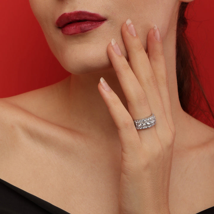 Close-up of a woman's hand wearing a diamond ring with a red background