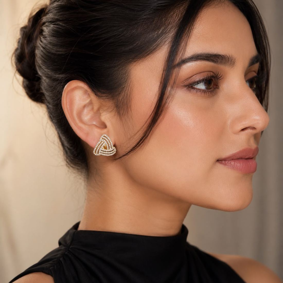 Woman wearing 925 Sterling Silver gold polish knot stud earrings with sparkling CZ stones