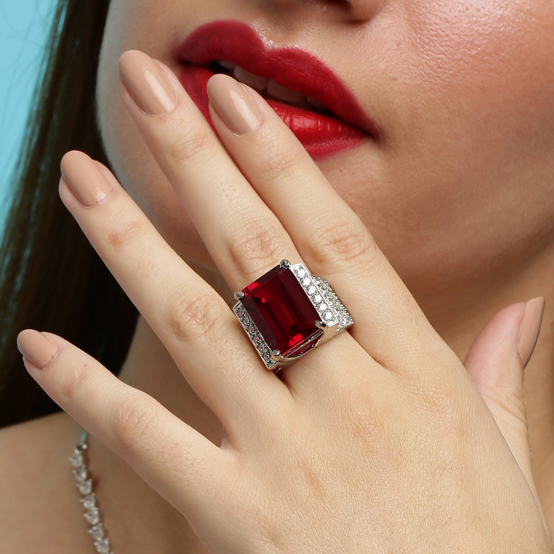 Close-up of model wearing 925 sterling silver ruby statement ring with red gemstone and diamond pavé band