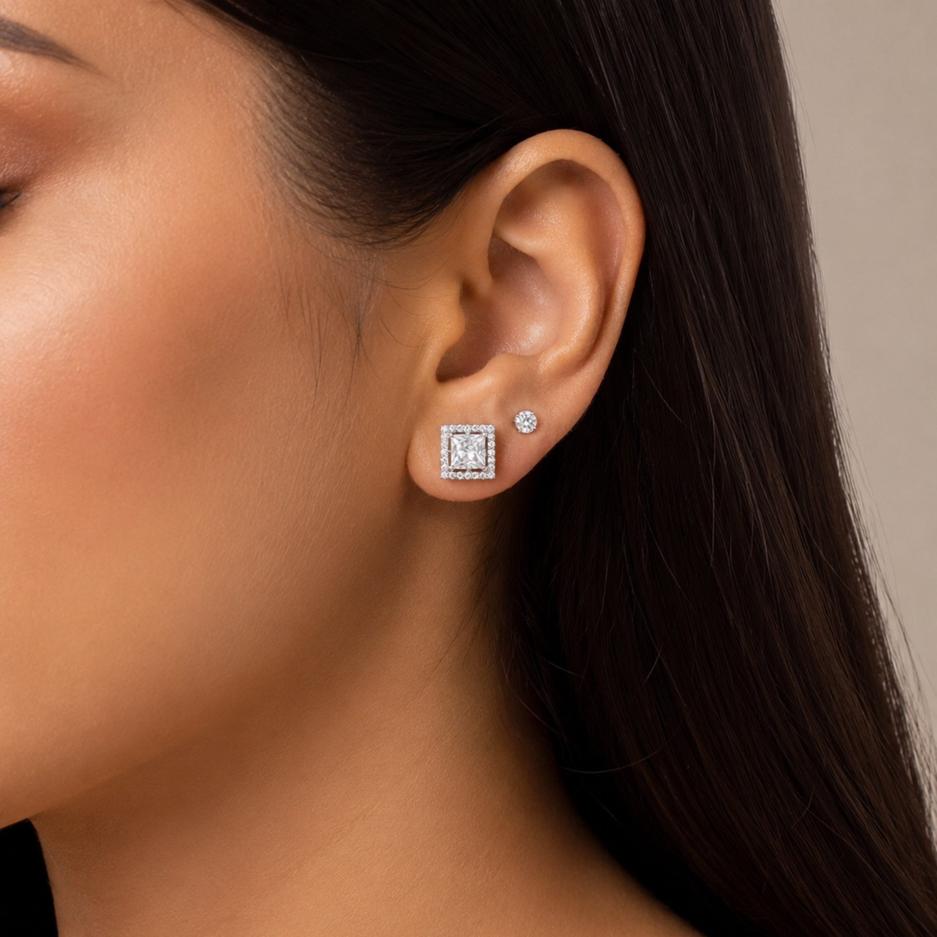 Woman wearing 925 sterling silver square halo stud earrings with princess cut stone and sparkling pave diamonds