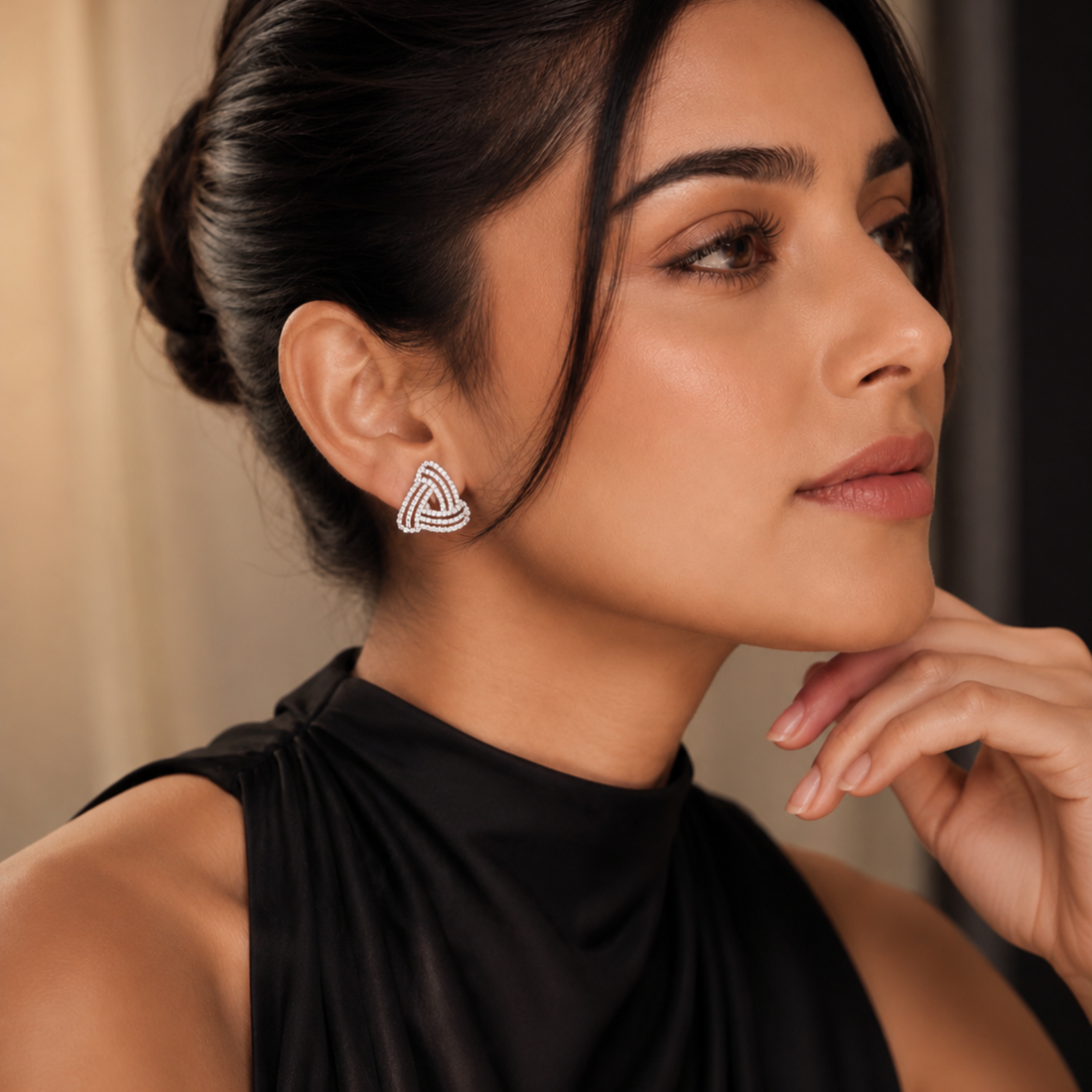 Woman wearing 925 Sterling Silver white polish knot stud earrings with sparkling CZ stones