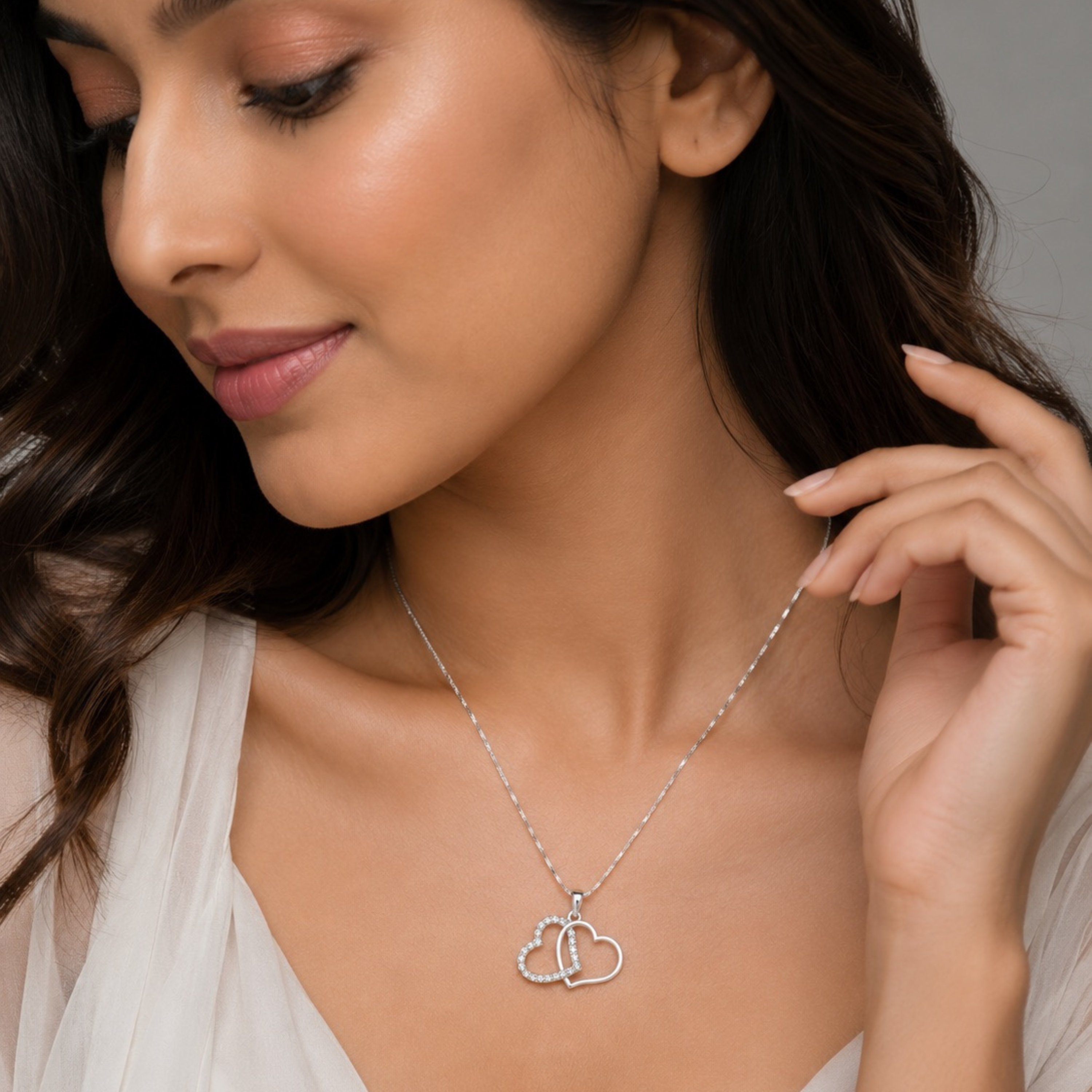 Model wear Amorielle twin heart pendant necklace in white polish with sparkling white stones