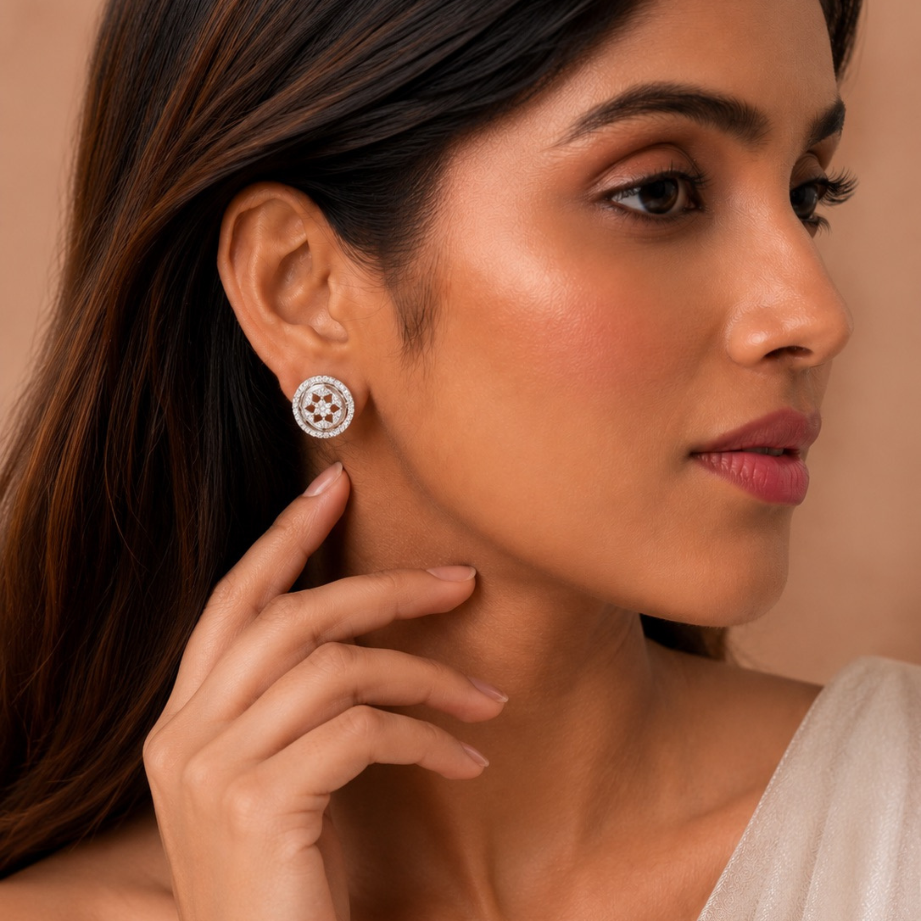 Elegant woman wearing white polish diamond stud earrings with soft glam pose